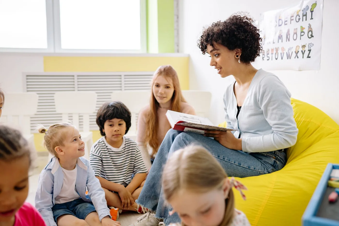 Illustrative photograph: A teacher sharing a story with young children